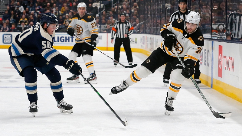 Boston Bruins left wing Jake DeBrusk (74) and Columbus Blue Jackets left wing Eric Robinson (50)