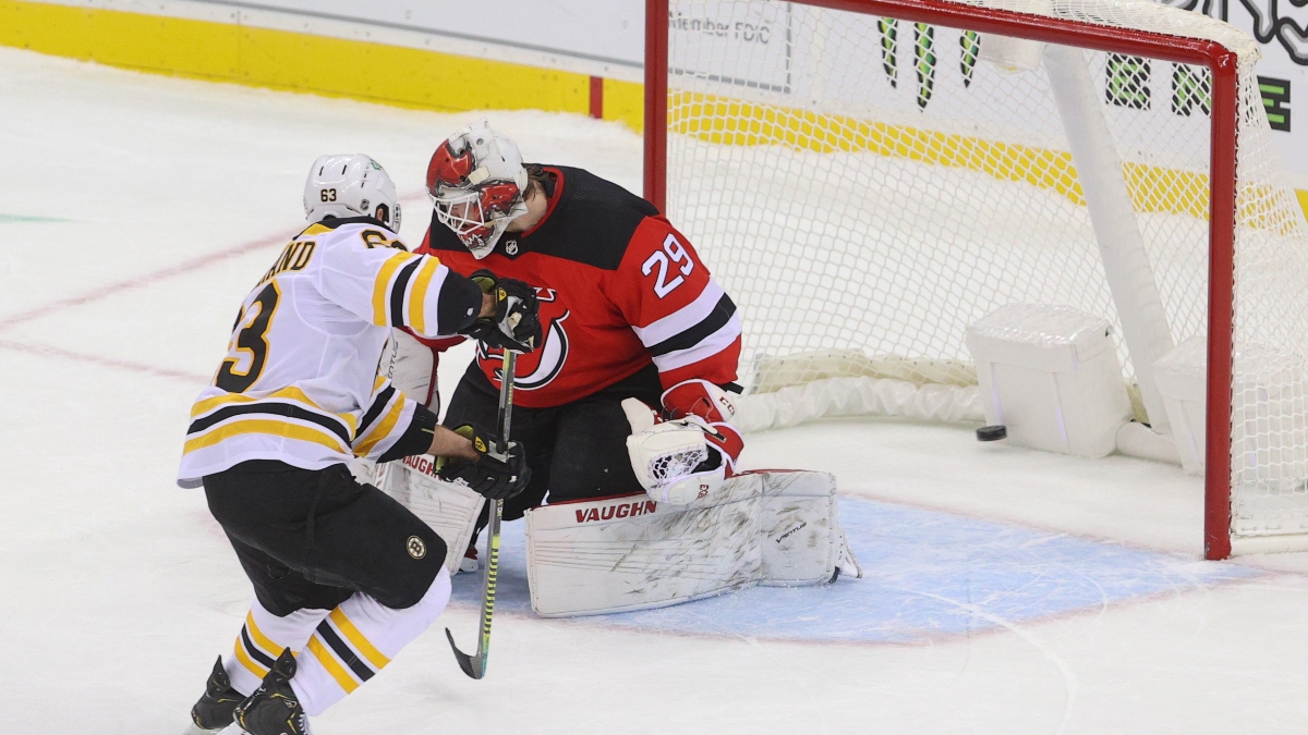 Boston Bruins left wing Brad Marchand (63) and New Jersey Devils goaltender Mackenzie Blackwood (29)