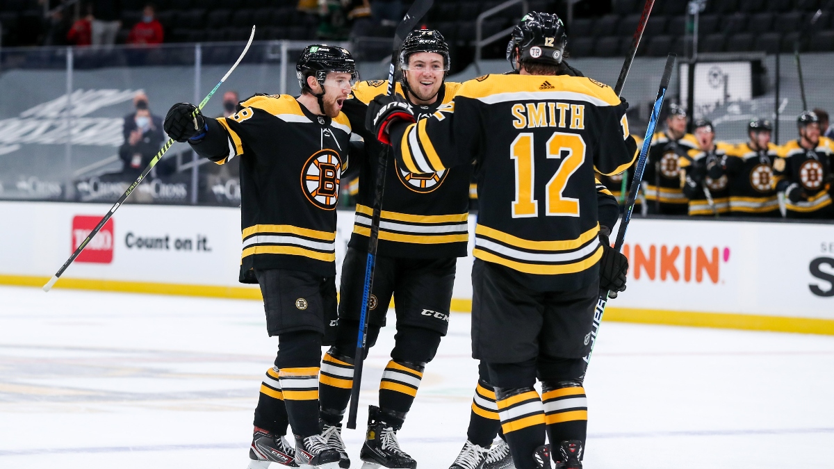 Boston Bruins defenseman Matt Grzelcyk (left), defenseman Charlie McAvoy (73) and center Craig Smith (12)