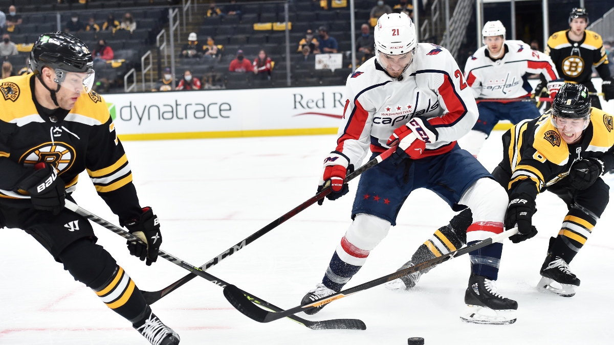 Boston Bruins left wing Taylor Hall (71) and defenseman Mike Reilly (6) and Washington Capitals right wing Garnet Hathaway (21)
