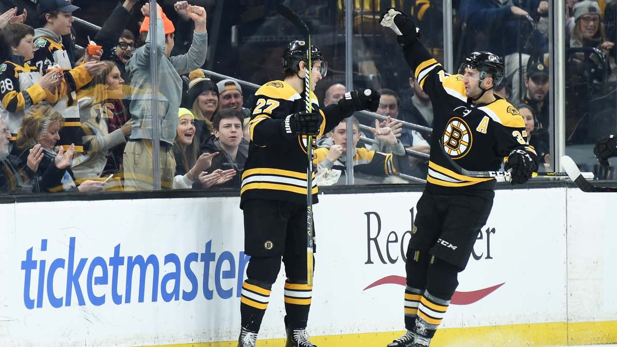 Boston Bruins defenseman John Moore and center Patrice Bergeron