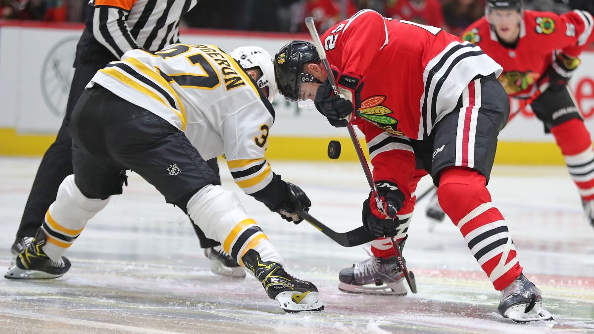 Chicago Blackhawks center Ryan Carpenter (22) and Boston Bruins center Patrice Bergeron (37)