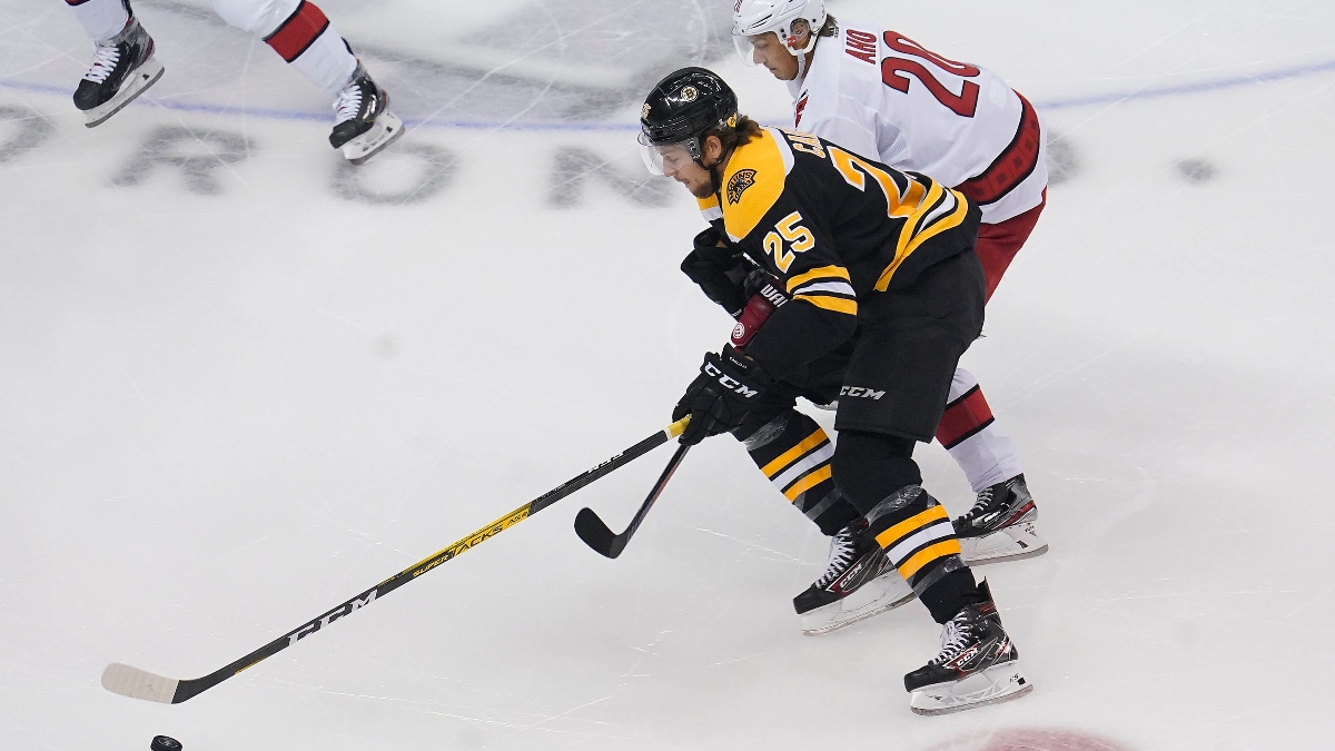 Boston Bruins defenseman Brandon Carlo (25) and Carolina Hurricanes center Sebastian Aho (20)