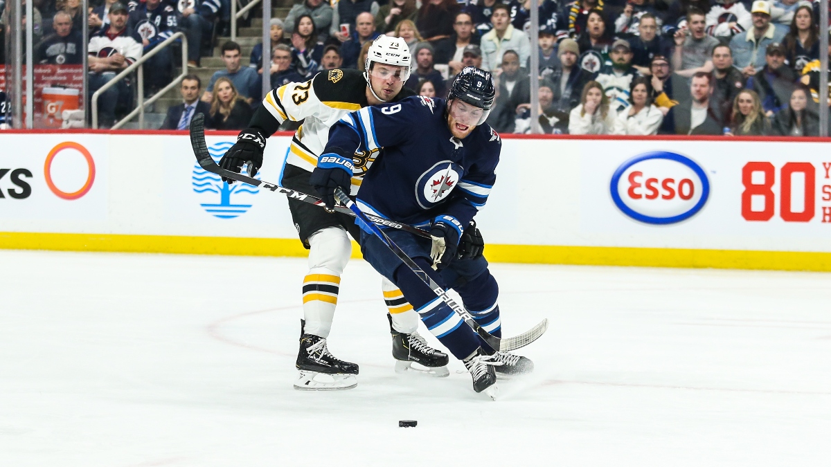 Winnipeg Jets forward Andrew Copp (9) and Boston Bruins defenseman Charlie McAvoy (73)