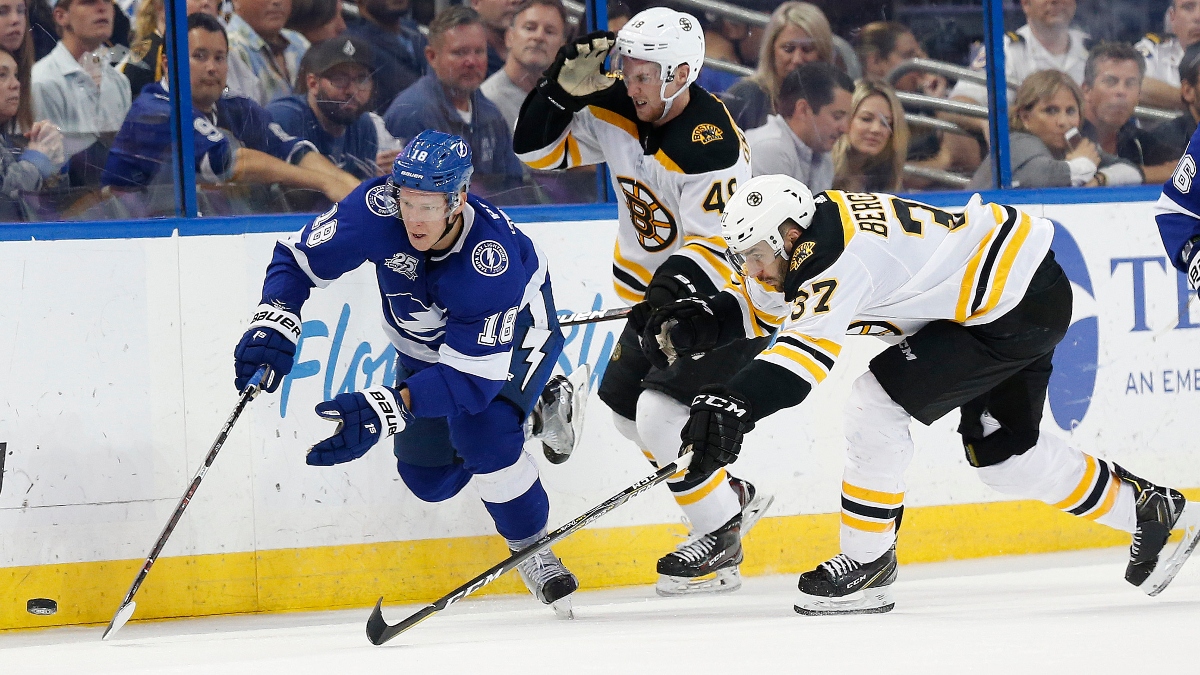 Tampa Bay Lightning left wing Ondrej Palat (18) and Boston Bruins defenseman Matt Grzelcyk (48) and center Patrice Bergeron (37)