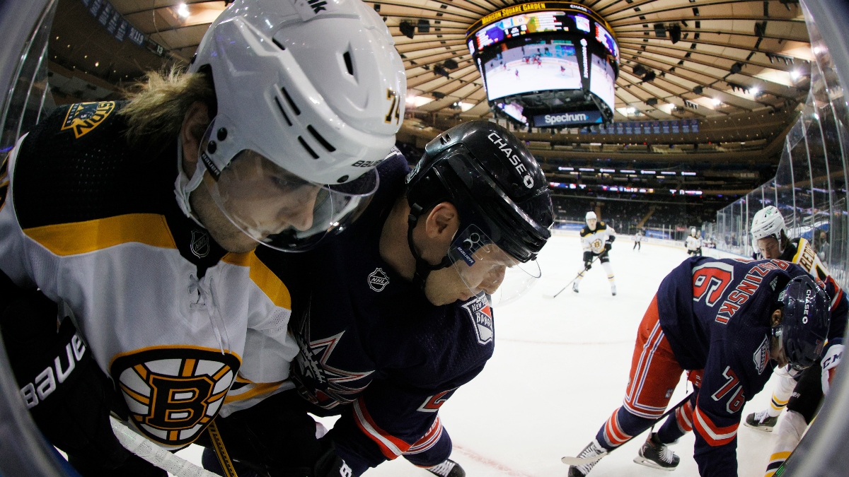 Boston Bruins forwards Jake DeBrusk (74) and Trent Frederic (11) and the New York Rangers' Jack Johnson (27) and Jonny Brodzinski (76)