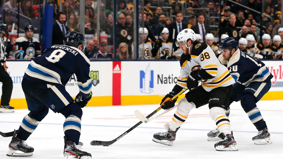 Boston Bruins right wing David Pastrnak (88) and Columbus Blue Jackets defenseman Zach Werenski (8)