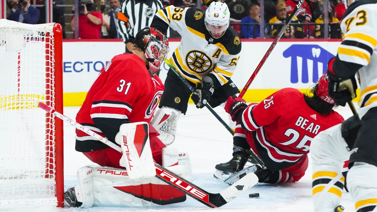 Boston Bruins left wing Brad Marchand (63) and Carolina Hurricanes goaltender Frederik Andersen (31) and defenseman Ethan Bear (25)