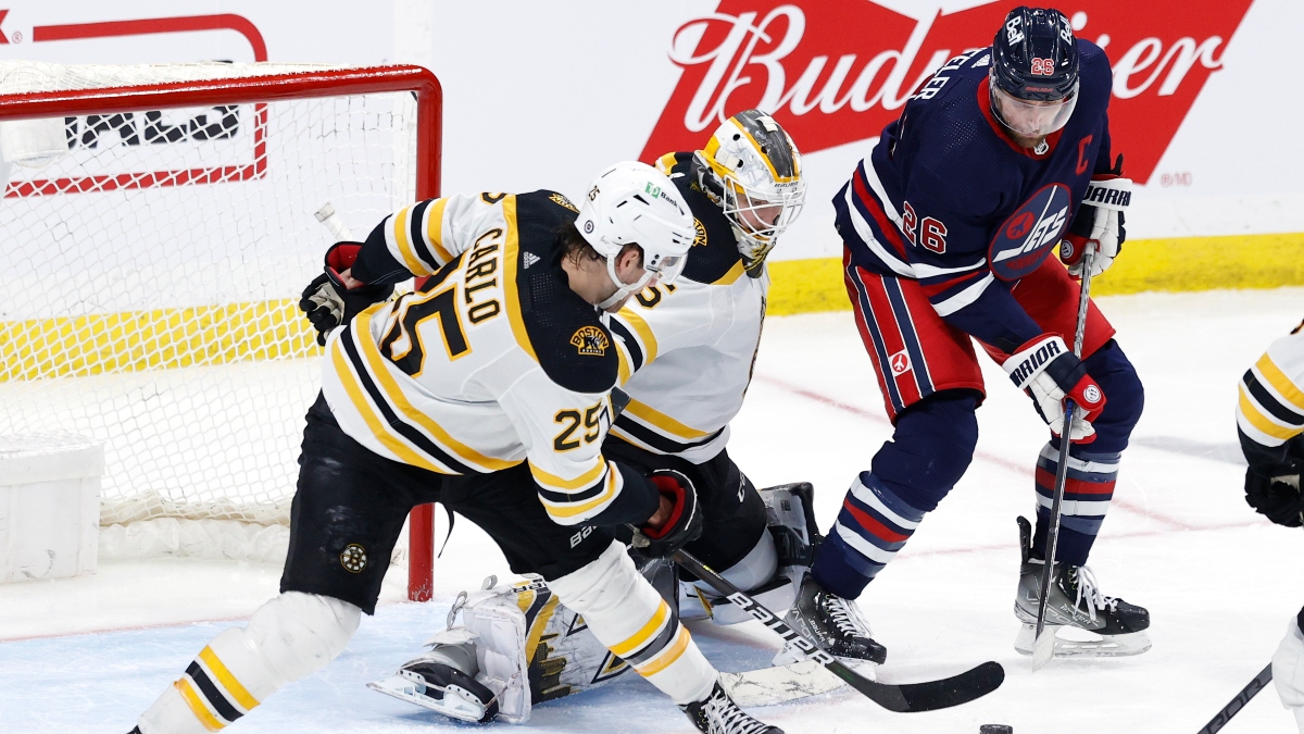 Boston Bruins defenseman Brandon Carlo (25) and goaltender Linus Ullmark (35) and Winnipeg Jets right wing Blake Wheeler (26)