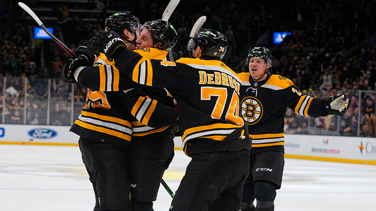 Boston Bruins left wing Erik Haula hugs Boston Bruins defenseman Brandon Carlo along with Boston Bruins left wing Jake DeBrusk