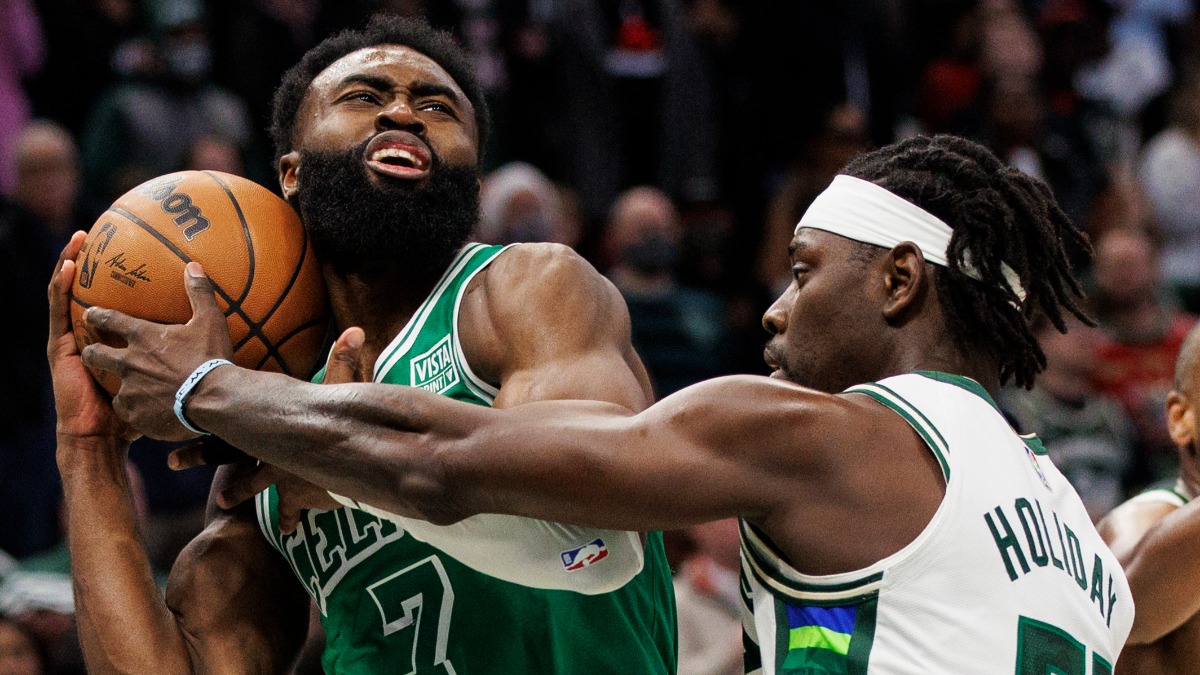 Milwaukee Bucks guard Jrue Holiday, fouls Boston Celtics guard Jaylen Brown