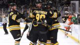 Boston Bruins players react after a goal