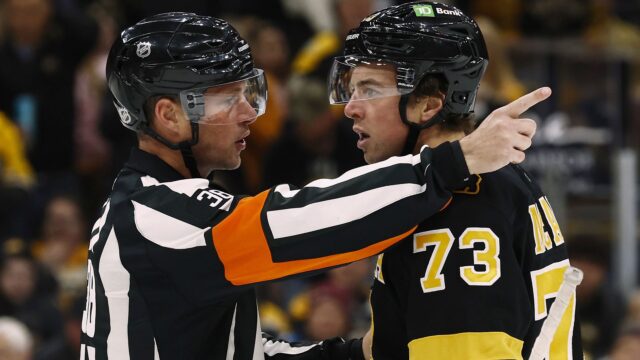Referee Peter MacDougall and Boston Bruins defenseman Charlie McAvoy